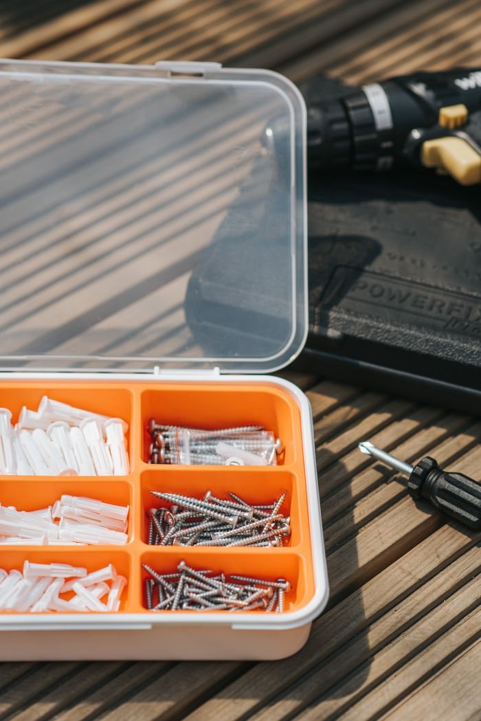 Organized fasteners and tools on a wooden work surface